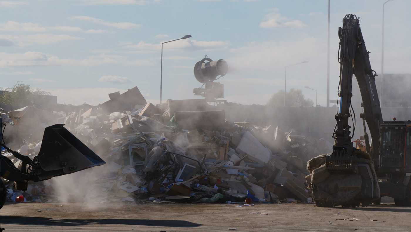 Chantier de démolition et de tri de déchets dégageant un important nuage de poussière